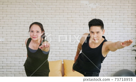 family couple doing YOGA standing meditating on virabhadrasana 3 pose workout 73718955