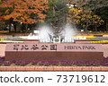 The name plate at the entrance of Hibiya Park, the background of autumn leaves and the fountain 73719612