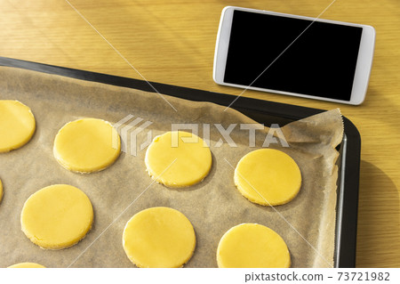 Image of making cookies by looking at a smartphone 73721982
