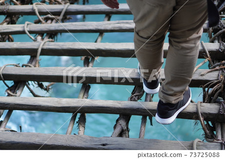 Bridge and men's feet Bridge and men's feet 73725088