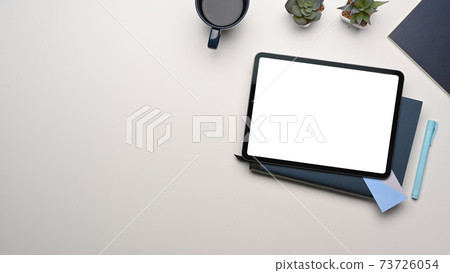 Overhead shot of mock up digital tablet with empty screen on whitetable. Blank screen for text message or information content. Overhead shot of mock up digital tablet with empty screen on whitetable. Blank screen for text message or information content. 73726054