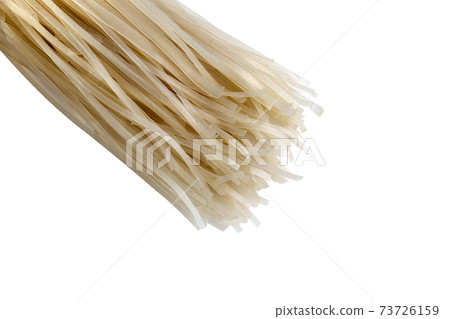 Rice noodles on a white background. Dry rice noodles close up on a white background. 73726159