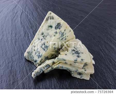 Cheese with mold on a board of stone. Gorgonzola cheese close-up on a surface of slate. 73726364