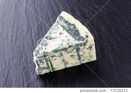 Cheese with mold on a board of stone. Gorgonzola cheese close-up on a surface of slate. 73726371