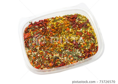 Dry seasoning in a plastic container. Different condiments in a container on a white background. Dry seasoning in a plastic container. Different condiments in a container on a white background. 73726570