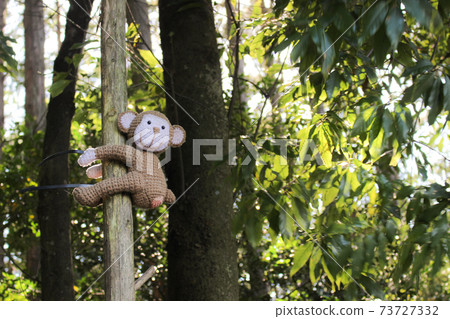 Stuffed monkey climbing a tree Stuffed monkey climbing a tree 73727332