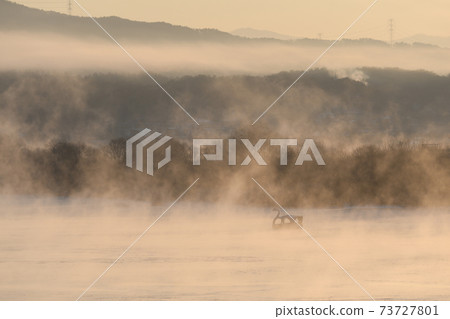 Water mist rising from the river on a winter morning 73727801