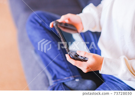Teenager playing with a game controller [e-sports] 73728030