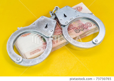 Handcuffs and money. Criminal penalty for fraud Handcuffs and money. Criminal penalty for fraud 73730765
