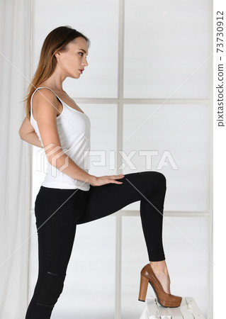 Woman stands in sexy model pose in high heels Woman stands in sexy model pose in high heels 73730912