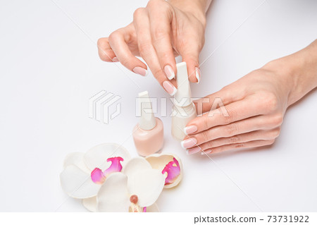 Beautiful Female Hands with French manicure over light grey background 73731922