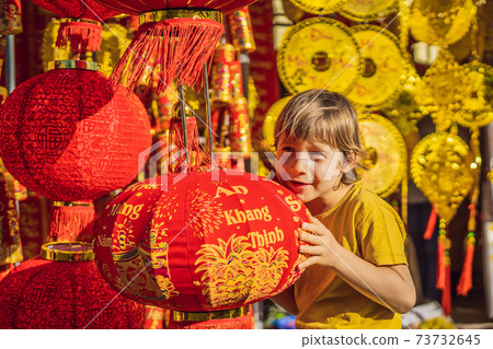 Caucasian tourist boy in Tet holidays. Vietnam Chinese Lunar New Year in springtime. TEXT TRANSLATION from Vietnamese: Congratulations on the Vietnamese, Chinese New Years and wishes of all the best Caucasian tourist boy in Tet holidays. Vietnam Chinese Lunar New Year in springtime. TEXT TRANSLATION from Vietnamese: Congratulations on the Vietnamese, Chinese New Years and wishes of all the best 73732645