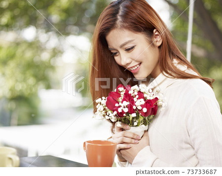 young asian woman in love holding flowers and smiling, valentine's day theme 73733687