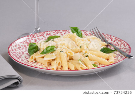 tempting cooked pasta with cheese and herbs on a plate 73734236