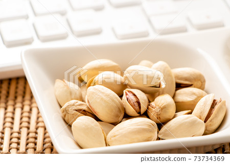 Snack image of online drinking party. Pistachio and keyboard. Snack image of online drinking party. Pistachio and keyboard. 73734369