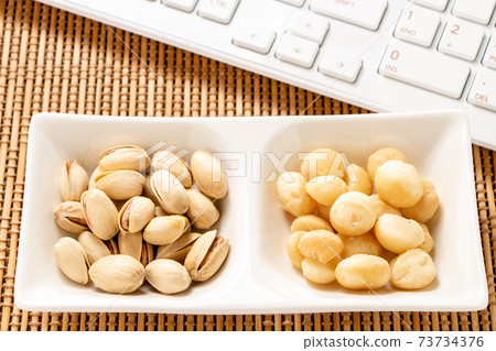 Snack image of online drinking party. Nuts (pistachio macadamia nuts) and keyboard. Snack image of online drinking party. Nuts (pistachio macadamia nuts) and keyboard. 73734376