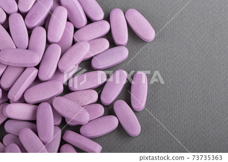 Heap of pink medical pills on a gray background. Health concept. Heap of pink medical pills on a gray background. Health concept. 73735363