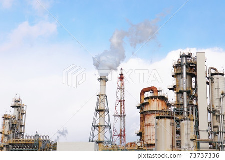 Smoke and flare stack from the chimney of an oil refinery 73737336