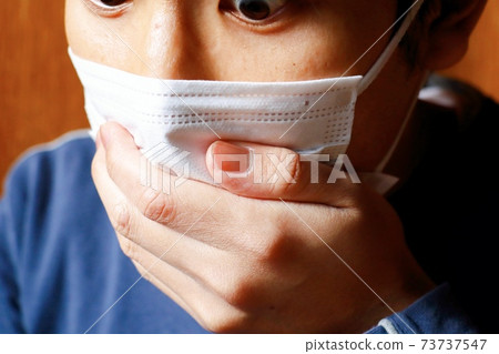 Japanese man putting his hand on his mouth 73737547