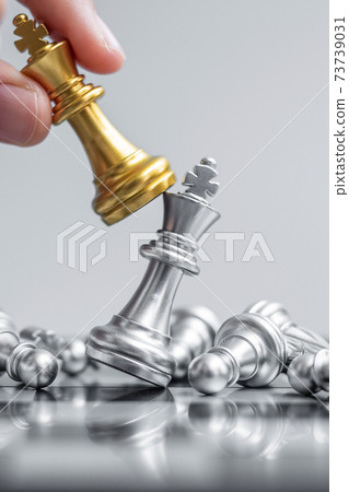 businessman hand moving gold Chess King figure and Checkmate enermy or opponent during chessboard competition. Strategy, Success, management, business planning, interruption and leadership concept businessman hand moving gold Chess King figure and Checkmate enermy or opponent during chessboard competition. Strategy, Success, management, business planning, interruption and leadership concept 73739031