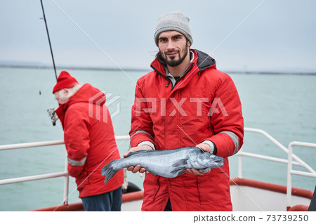 Fisherman holding fish catch at hands after the fishing 73739250