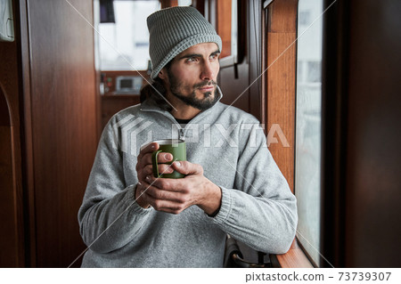 Man smiling and drinking coffee in the morning at the boat Man smiling and drinking coffee in the morning at the boat 73739307