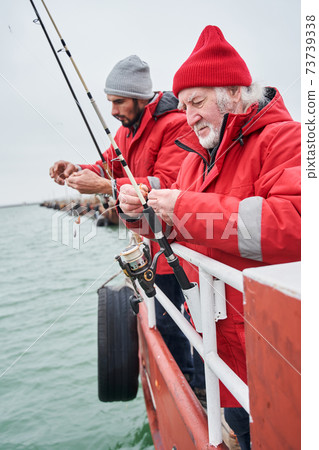 Men with spinnings standing on the boat while fishing 73739338