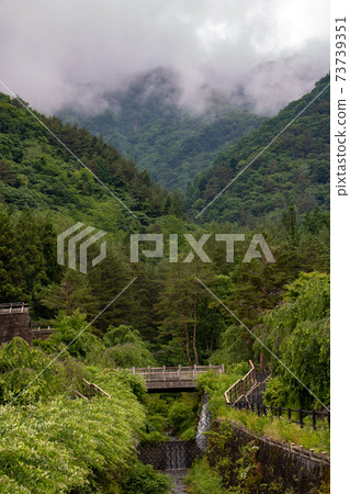 A clouds cover the tops of the hills around Saiko lake, Japan. A clouds cover the tops of the hills around Saiko lake, Japan. 73739351