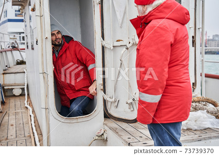 Two fishermans communicating with each other at the deck 73739370
