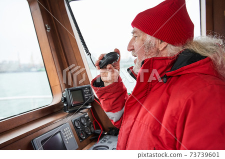 Senior man talking something at the walkie-talkie 73739601