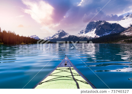 Kayaking in a glacier lake during a vibrant sunny summer morning. Kayaking in a glacier lake during a vibrant sunny summer morning. 73740327