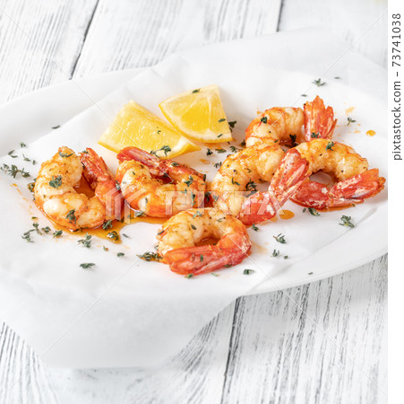 Shrimps with thyme and lemon wedges Shrimps with thyme and lemon wedges 73741038