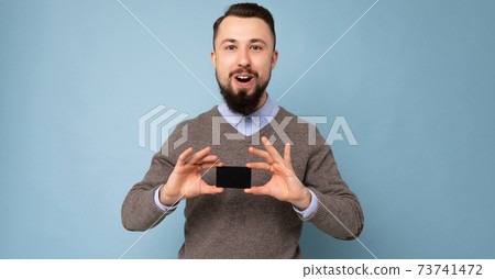 Panoramic photo of Surprised Handsome smiling brunette bearded adult man wearing grey sweater and Panoramic photo of Surprised Handsome smiling brunette bearded adult man wearing grey sweater and 73741472