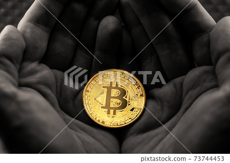 Physical bitcoin held in hands close up photo in selective colors Physical bitcoin held in hands close up photo in selective colors 73744453