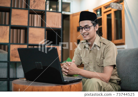 man in civilian uniform looking screen monitor while use laptop 73744525