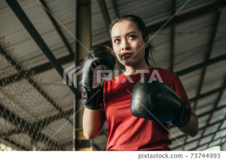woman ultimate fighter in boxing gloves with movement hands defend beside copyspace woman ultimate fighter in boxing gloves with movement hands defend beside copyspace 73744993