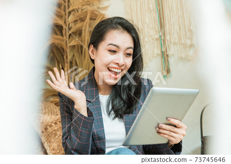 a happy beautiful woman in a blazer uses a digital tablet a happy beautiful woman in a blazer uses a digital tablet 73745646