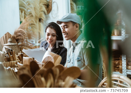 man and woman business partners look at paper while working man and woman business partners look at paper while working 73745709