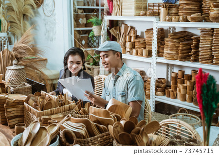 a craftsman gives a paper craft item sketch to a businesswoman a craftsman gives a paper craft item sketch to a businesswoman 73745715
