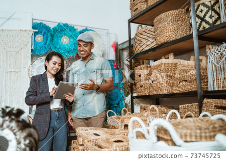 woman and man entrepreneurs list items using a tablet in the craft gallery woman and man entrepreneurs list items using a tablet in the craft gallery 73745725