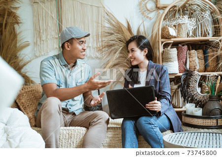 Craft business owner and client with hands gesture chatting while using laptop computer 73745800