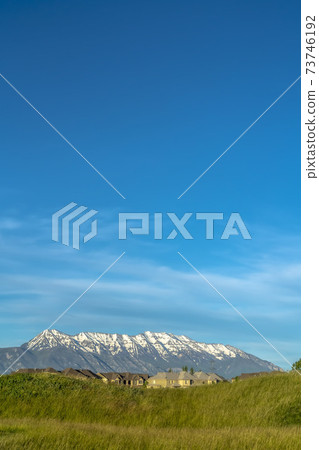 Neighborhood on a hill with amazing view of snow peaked mountain and blue sky Neighborhood on a hill with amazing view of snow peaked mountain and blue sky 73746192