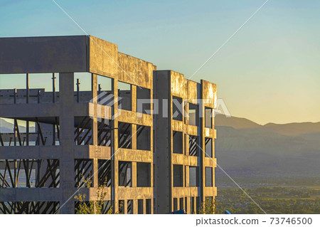 COnstruction of a new building with mountain and sky background at sunset 73746500
