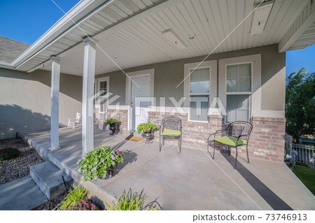 Covered porch at the front of an urban house 73746913