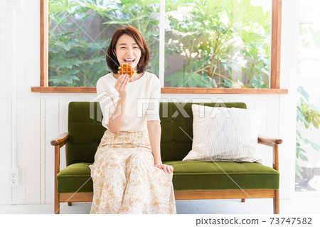 Woman eating waffles 73747582