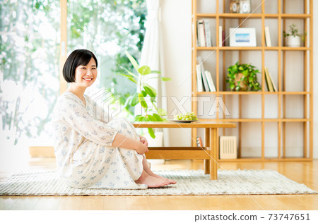 坐在客廳裡的年輕女子 73747651