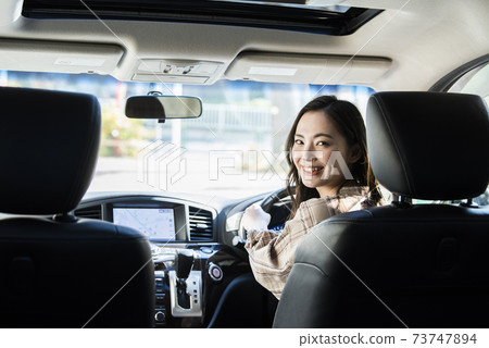 A young woman driving a car 73747894