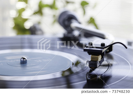 Listen to music on a record player by the window where the sun shines Listen to music on a record player by the window where the sun shines 73748230