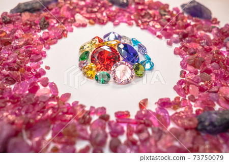 colorful diamonds surrounded by raw pink gemstones. colorful diamonds surrounded by raw pink gemstones. 73750079