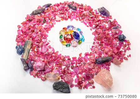 colorful diamonds surrounded by raw pink gemstones. 73750080